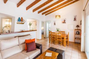 a living room with a couch and a table at Villa Es Mirador in Son Bou