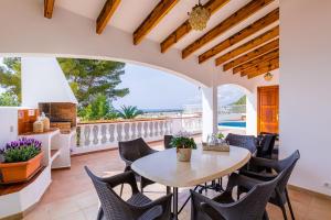 a dining room with a table and chairs on a patio at Villa Es Mirador in Son Bou