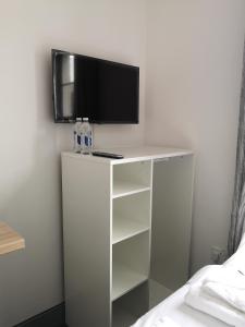 a tv on top of a white cabinet with shelves at Ty'r Bont Studios in Newtown
