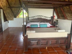 um quarto com uma cama de madeira e 2 almofadas azuis em Casa Maria em El Cebollito