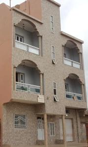 un edificio con arcos en el costado en Appartement meublé à MBAO en Mbaw Gou Ndaw