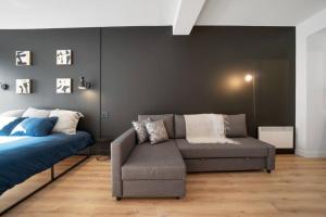 una sala de estar con un sofá y una cama en INITIAL - SUITE LUMIÈRE - Centre-Ville de Québec, en Quebec