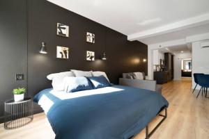 Un dormitorio con una cama azul con una pared negra. en INITIAL - SUITE LUMIÈRE - Centre-Ville de Québec, en Quebec