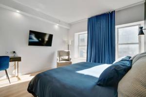 Un dormitorio con una cama y un escritorio y una ventana. en INITIAL - SUITE LUMIÈRE - Centre-Ville de Québec, en Quebec