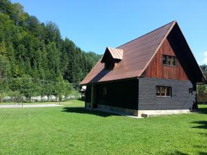 a barn with a gambrel roof on a grass field at Chata Sipkova I in Terchová