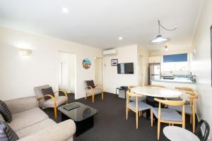 a living room with a couch and a table and chairs at Chevron Motel in Taupo