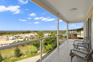 a balcony with two chairs and a view of a town at Eastern Views Beach House - Spacious Family Escape in Lakes Entrance