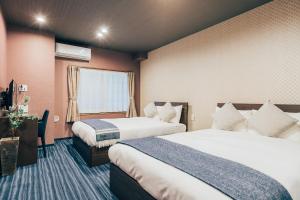 a hotel room with two beds and a window at Playsis Asakusa in Tokyo