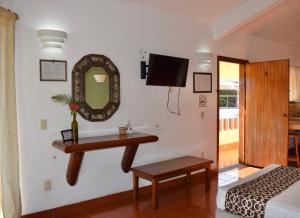 - une chambre avec un miroir, une table et un lit dans l'établissement Hotel Casa Arena, à Zihuatanejo