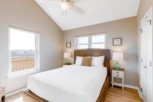 1 dormitorio con 1 cama y 2 ventanas en Little House on the Bay, en Galveston