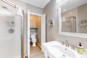 Un baño blanco con lavabo e inodoro. en Little House on the Bay, en Galveston 25 fotos más