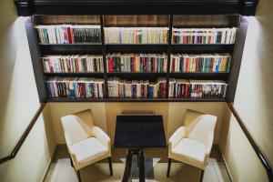 a room with two chairs and a book shelf with books at Biała Akacja Resort & Business in Prudnik +76 photos