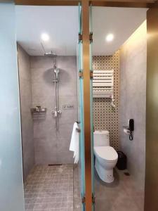 a bathroom with a shower and a toilet in it at Happy Dragon Universal Vacation Hotel - close to Universal Studio and Wanda Plaza,free shuttle to the Resort,Free Coffee,Laundry in Beijing