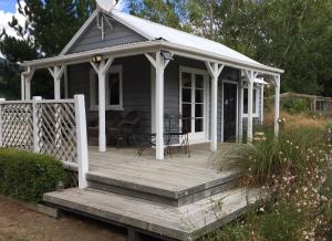 une petite maison avec une terrasse couverte et une terrasse dans l'établissement Birch Hill Cottage -30 minutes from St Arnaud, à Wairau Valley