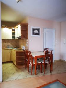 a kitchen with a table and chairs in a room at Apartament Reymonta przy morzu in Kołobrzeg