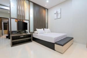 a bedroom with a bed and a flat screen tv at Sun In Pangandaran Hotel in Pangandaran