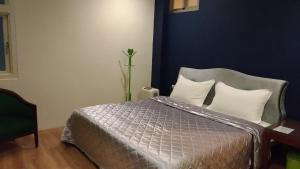 1 dormitorio con cama y pared azul en Good Time B&B, en Jiufen