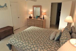 a bedroom with a bed and a dresser and a mirror at Steps from the Gulf of Mexico in Holmes Beach