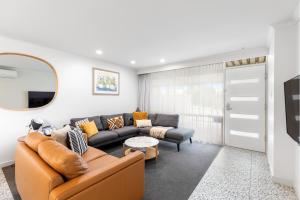 uma sala de estar com um sofá e uma mesa em City Courtyard Two Apartment em Mount Gambier