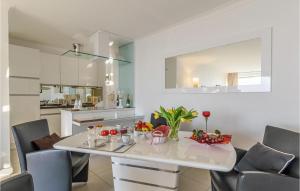 a kitchen and dining room with a white table and chairs at Cozy Apartment In Timmendorfer-strand With Wifi in Timmendorfer Strand