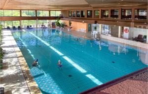 a large swimming pool with people in the water at Cozy Apartment In Timmendorfer-strand With Wifi in Timmendorfer Strand