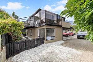 a house with a balcony on top of it at Kiwi style home! Views of lake. Large outdoor area in Queenstown