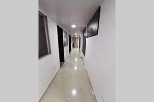 サン・ラファエルにあるHermoso y cómodo apartamentoの白い壁と白いタイルフロアの廊下