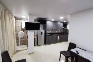 cocina con TV, mesa y sillas en Hermoso y cómodo apartamento, en San Rafael