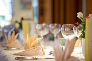 - une table avec des verres à vin et des fleurs dans l'établissement Landgasthof & Brauerei Löwen Sasbach, à Sasbach in der Ortenau