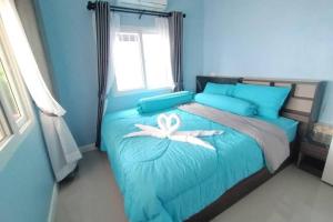 - une chambre bleue avec un lit orné d'une fleur blanche dans l'établissement Jayden's HomeStay, à Ko Sukon