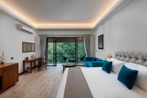 a bedroom with a large bed with blue pillows at Moksha at Kitulgala - Rainforest Boutique Hotel in Kitulgala