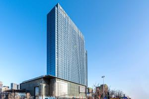 a tall skyscraper in a city at Happy Dragon Universal Vacation Hotel - close to Universal Studio and Wanda Plaza,free shuttle to the Resort,Free Coffee,Laundry in Beijing