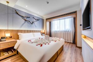 a bedroom with a large white bed with decorations on it at Happy Dragon Universal Vacation Hotel - close to Universal Studio and Wanda Plaza,free shuttle to the Resort,Free Coffee,Laundry in Beijing