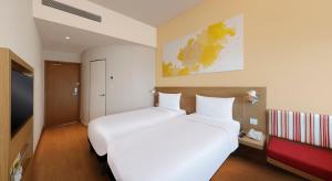 浦那ibis Pune Hinjewadi - An Accor Brand的一间有两张床和一台电视的酒店房间