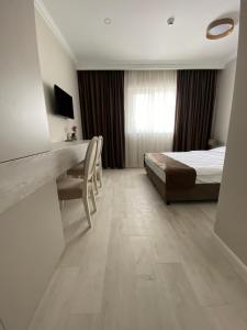 a hotel room with a bed and a desk and a desk at Pensiunea Agroturistica Marco in Dumbrăviţa