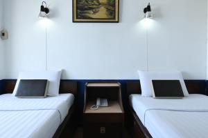 Un pat sau paturi într-o cameră la The Krungkasem Srikrung Hotel