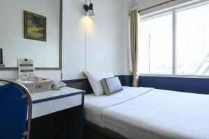 une chambre avec un grand lit et une fenêtre dans l'établissement The Krungkasem Srikrung Hotel, à Bangkok
