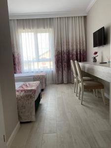 a room with a table and chairs and a bedroom at Pensiunea Agroturistica Marco in Dumbrăviţa +15 photos