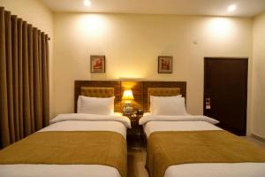 Postel nebo postele na pokoji v ubytování Hotel One Lalazar Multan