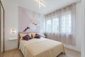 - une chambre blanche avec un grand lit et des oreillers violets dans l'établissement Apartments Niro, à Split