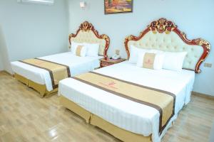 Duas camas num quarto com paredes azuis em Khách Sạn Phượng Hoàng 3 em Thanh Hóa