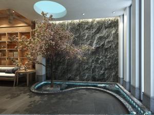 a tree in a room with a stone wall at Happy Dragon Universal Vacation Hotel - close to Universal Studio and Wanda Plaza,free shuttle to the Resort,Free Coffee,Laundry in Beijing