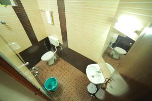 ein Badezimmer mit 2 WCs und einem Waschbecken in der Unterkunft Hotel Falcon in Thiruvananthapuram