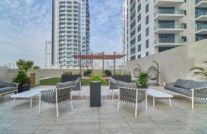 a patio with chairs and tables and buildings at Stella Stays Charming 1 BDR Dubai JVC Large Terrace in Dubai