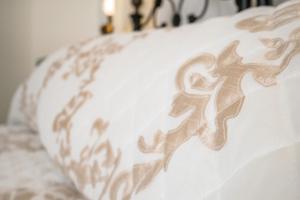 a white pillow with a brown design on it at Kharmen A 1565s House with Seaviews in Birgu