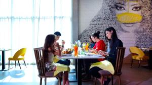 a group of people sitting at a table in a restaurant at Pullman Sharjah in Sharjah