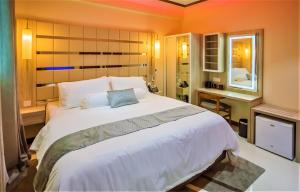 sypialnia z dużym białym łóżkiem i lustrem w obiekcie Avoca Inn w mieście Hulhumale