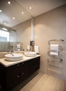 a bathroom with two sinks and a large mirror at Smygehus Havsbad in Smygehamn