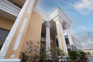 a facade of a building with columns at Hotel One Tariq Road Multan in Multan