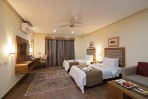 木尔坦Hotel One Tariq Road Multan的有两张床和一张沙发的酒店房间